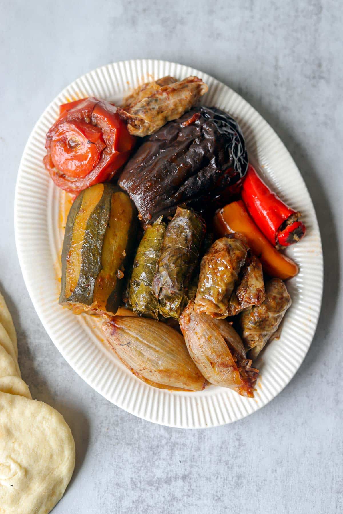 Iraqi Dolma on a white plate with pita bread next to it