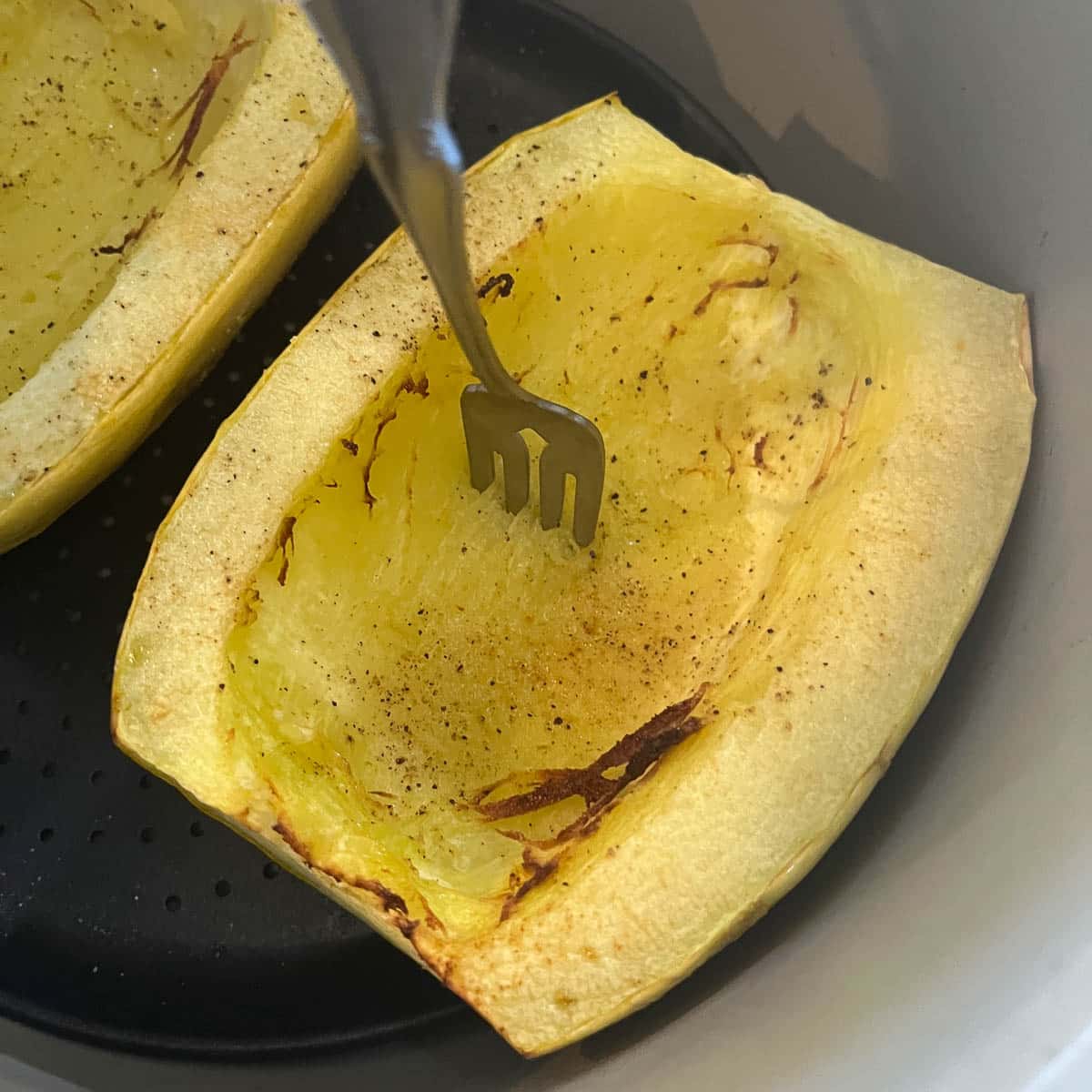 half of a spaghetti squash with a fork stuck  into it