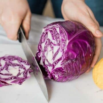 red cabbage being chopped on a cutting board