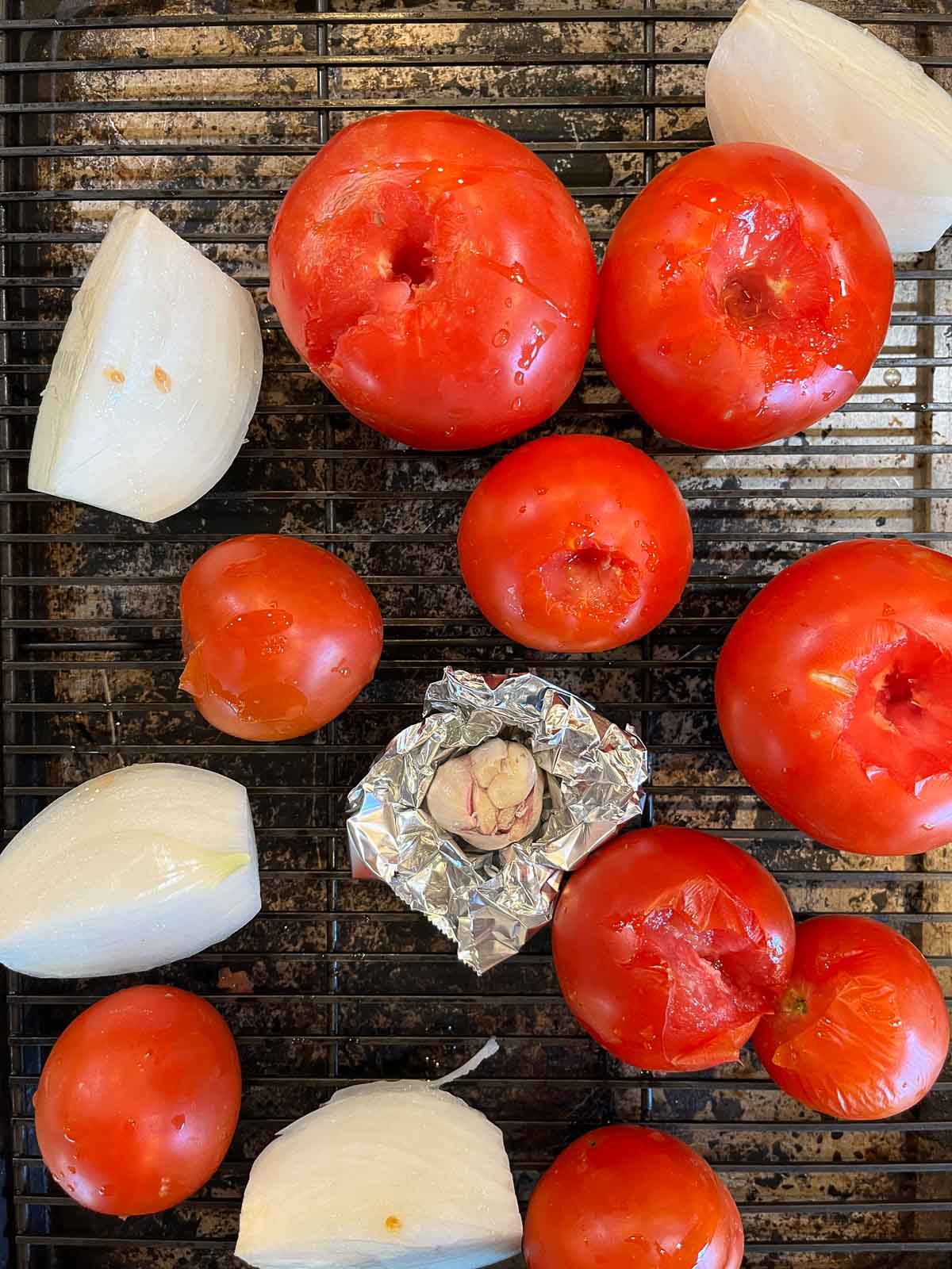 tomatoes, onion, and garlic on a cookie sheet