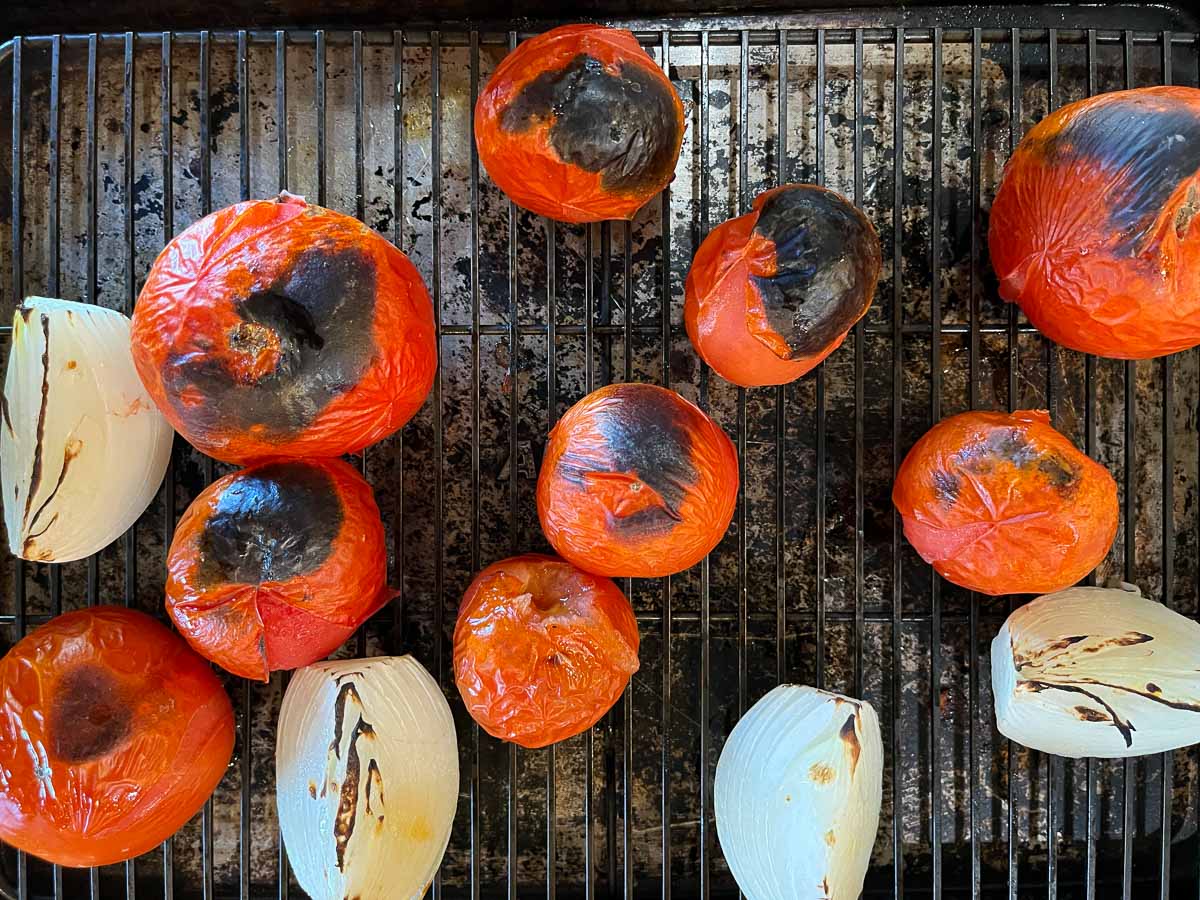 charred tomatoes and onions on a cookie sheet