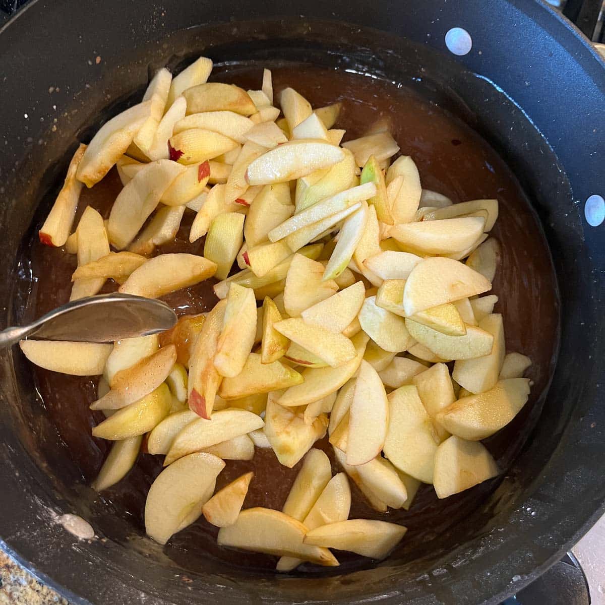sliced apples on top of jell in a pot