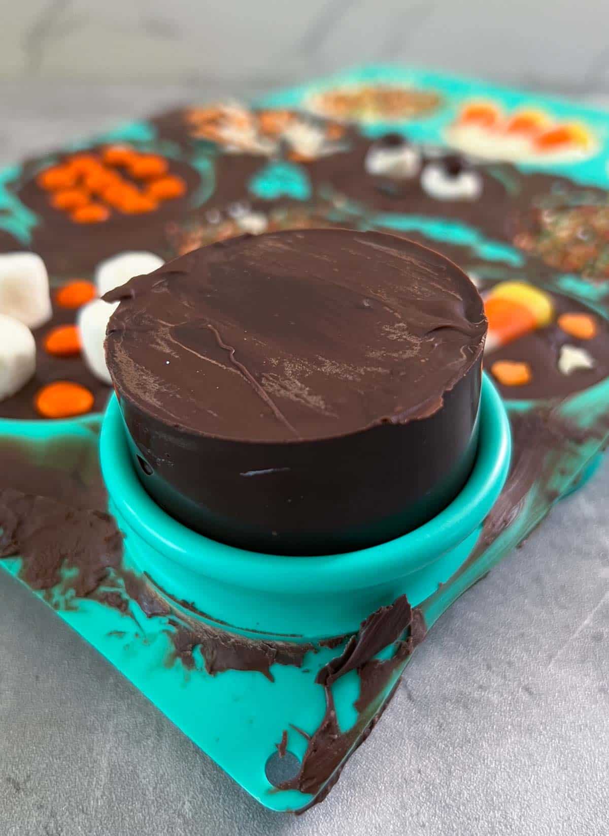 chocolate covered oreos being removed from mold