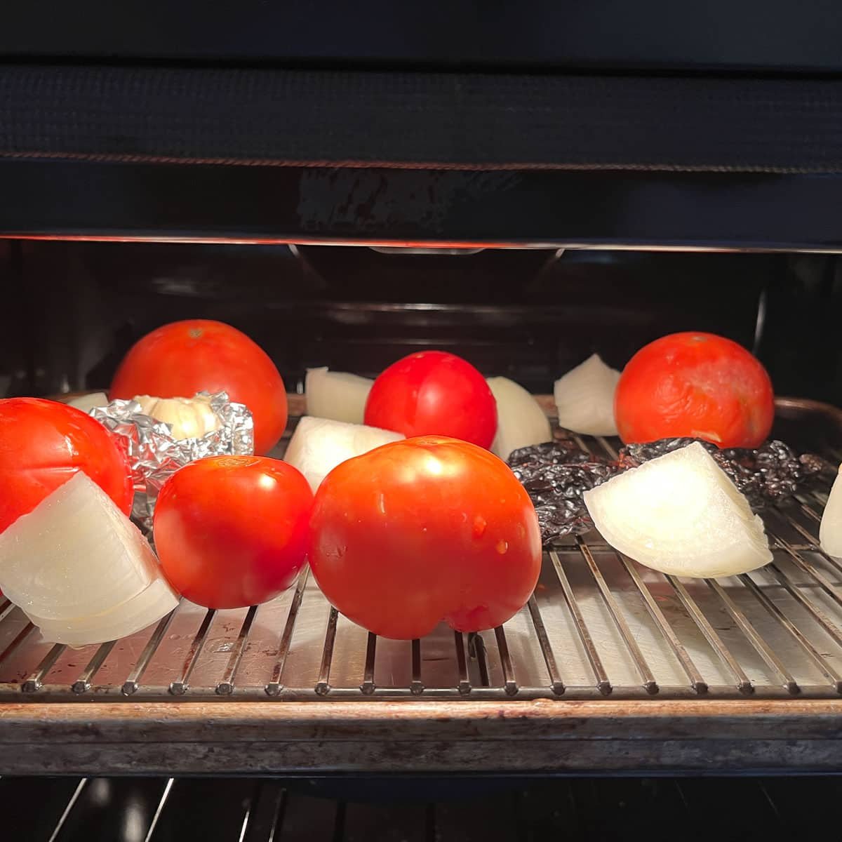 tomatoes and onion being roasted for elk chili recipe