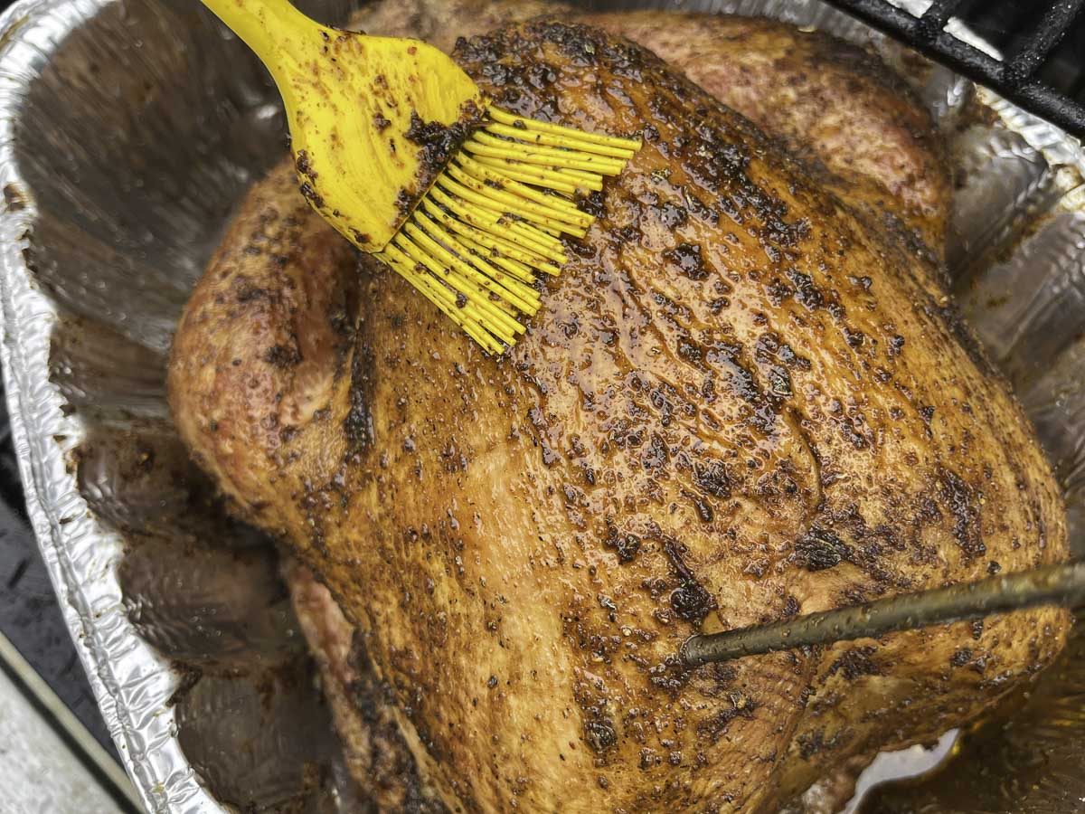 brushing a turkey with pan juices