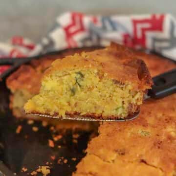 jiffy cornbread with creamed corn in a cast iron pan with a slice removed