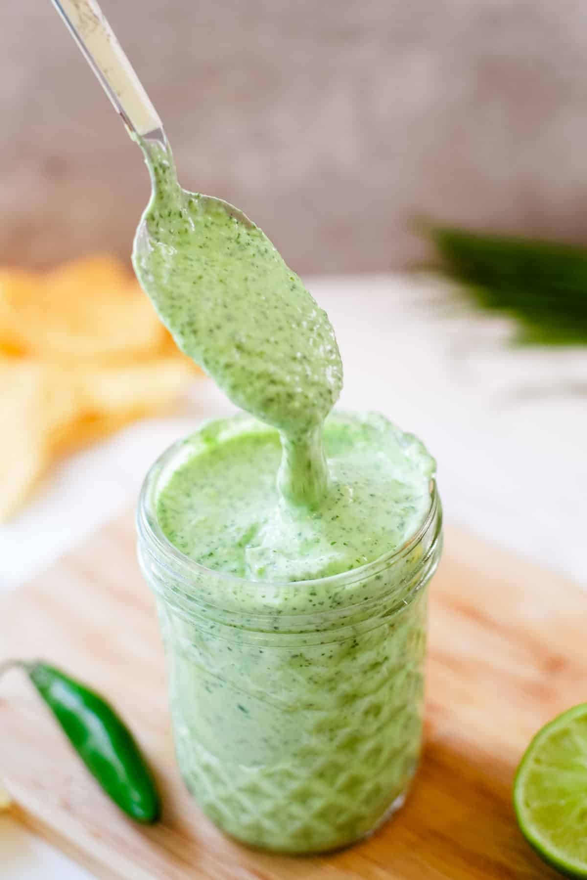spoon drizzling creamy cilantro sauce