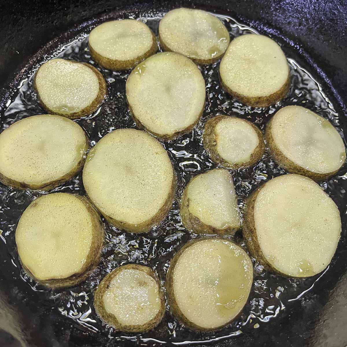potato slices frying in a pan