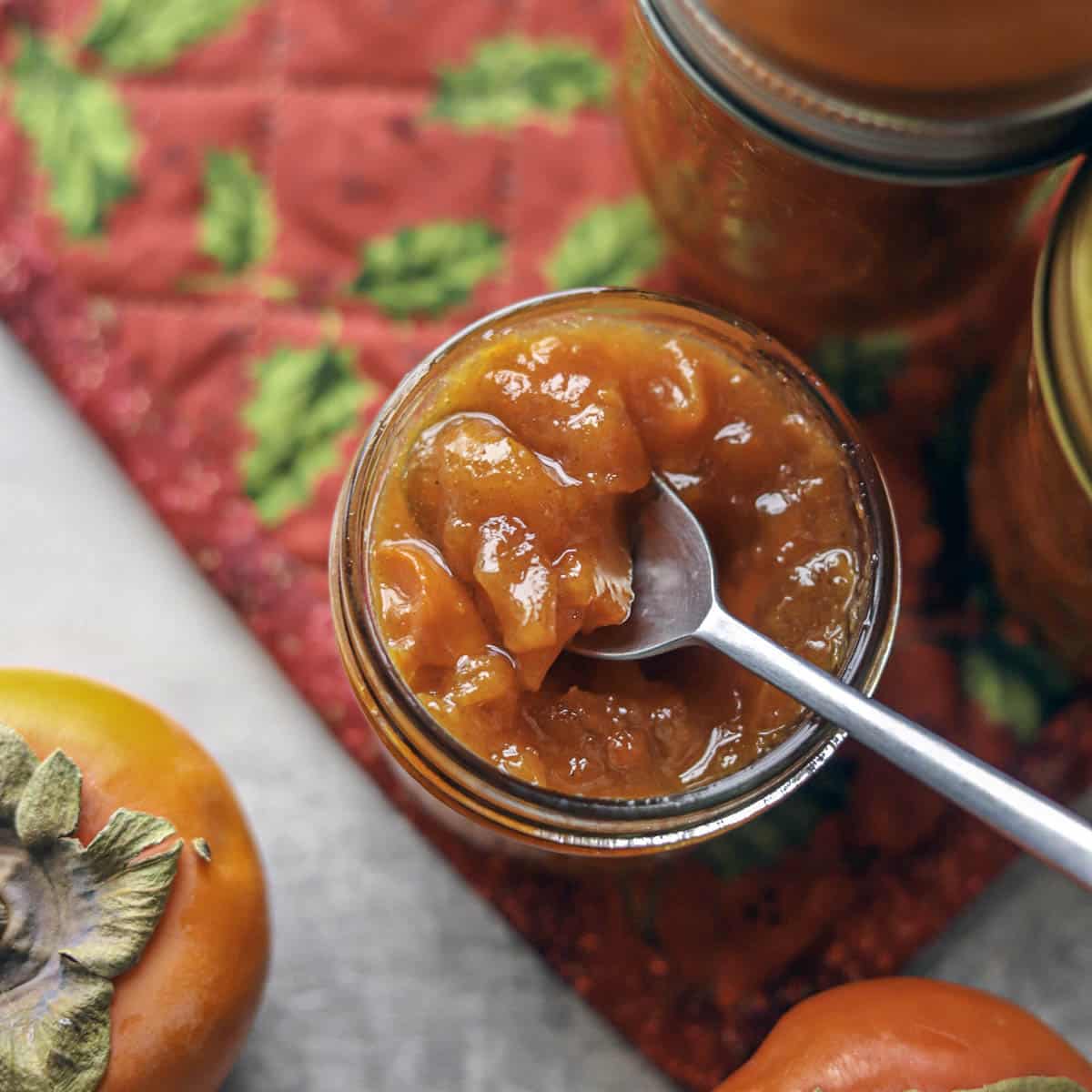 persimmon preserves with a spoon in the jar