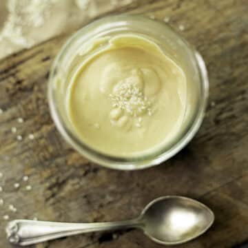tahini sauce in a jar with a spoon under it