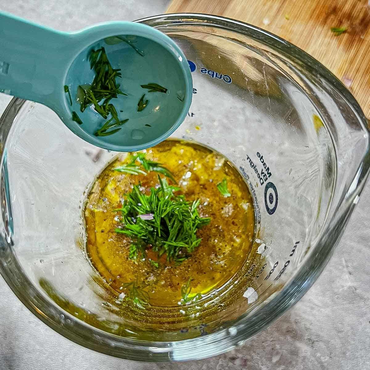 dill being added to vinaigrette