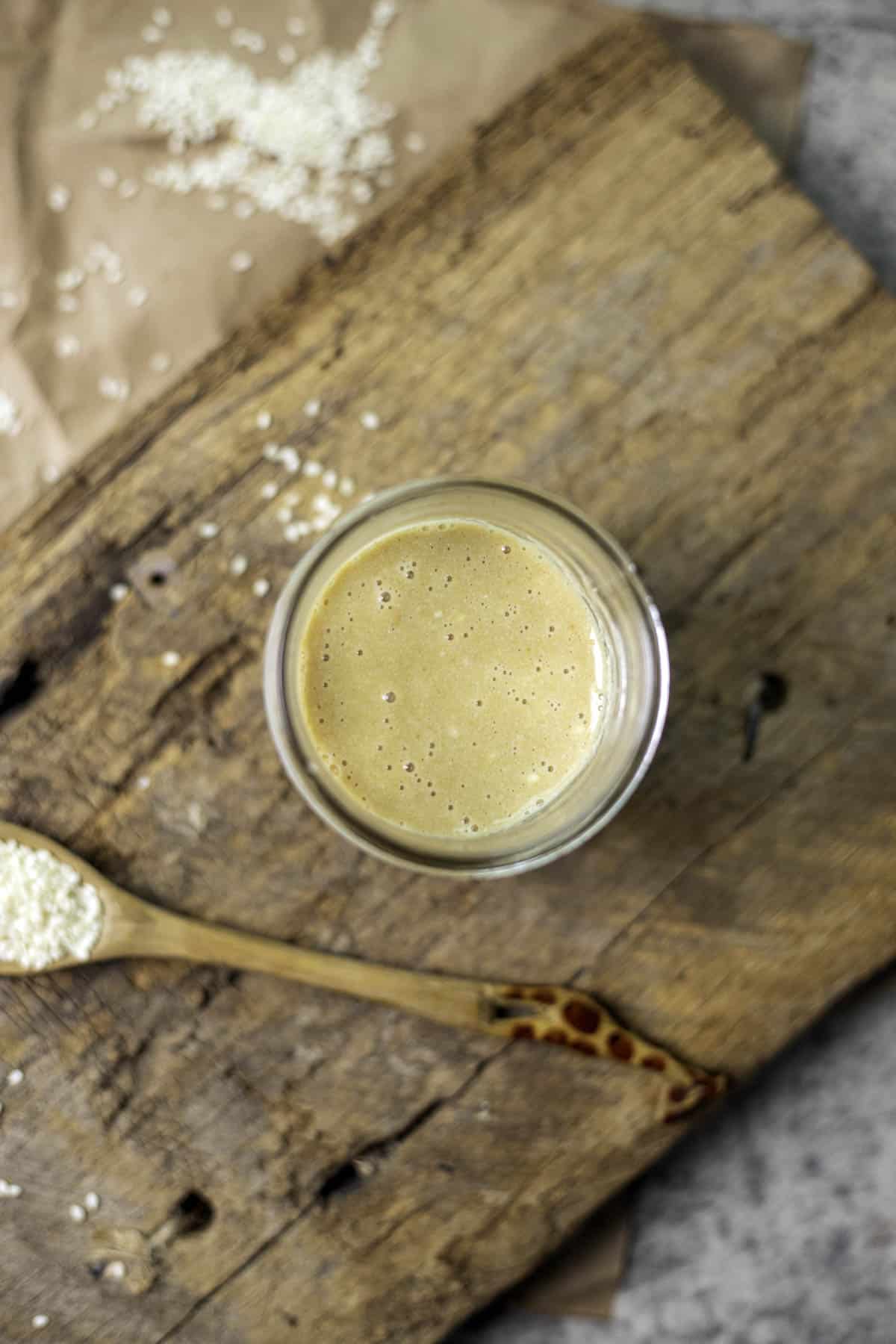 tahini paste in a jar on a wooden surface.