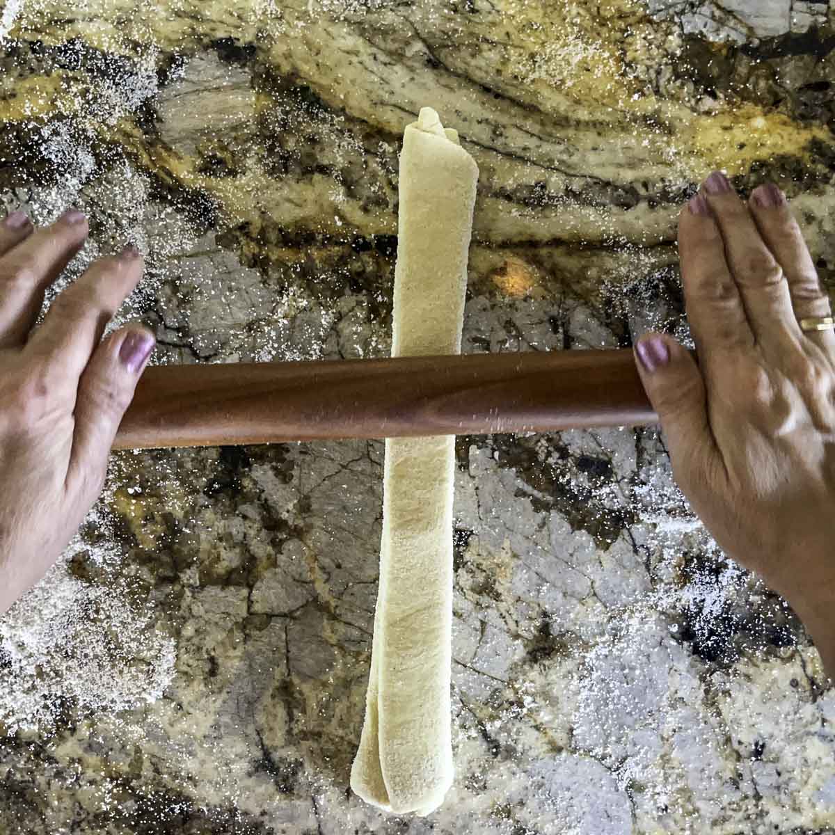 folded puff pastry being rolled out