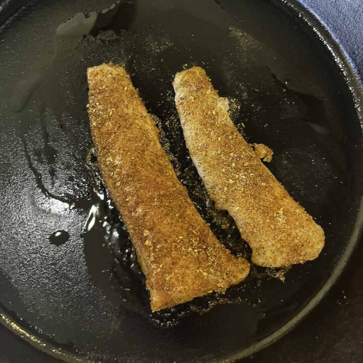 cod fillets being cooked in a pan
