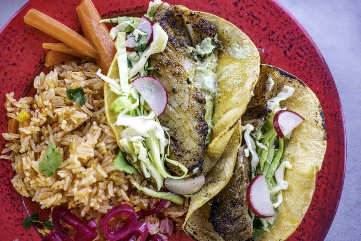 blackened fish tacos with rice on a red plate
