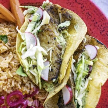 blackened fish tacos on a red plate