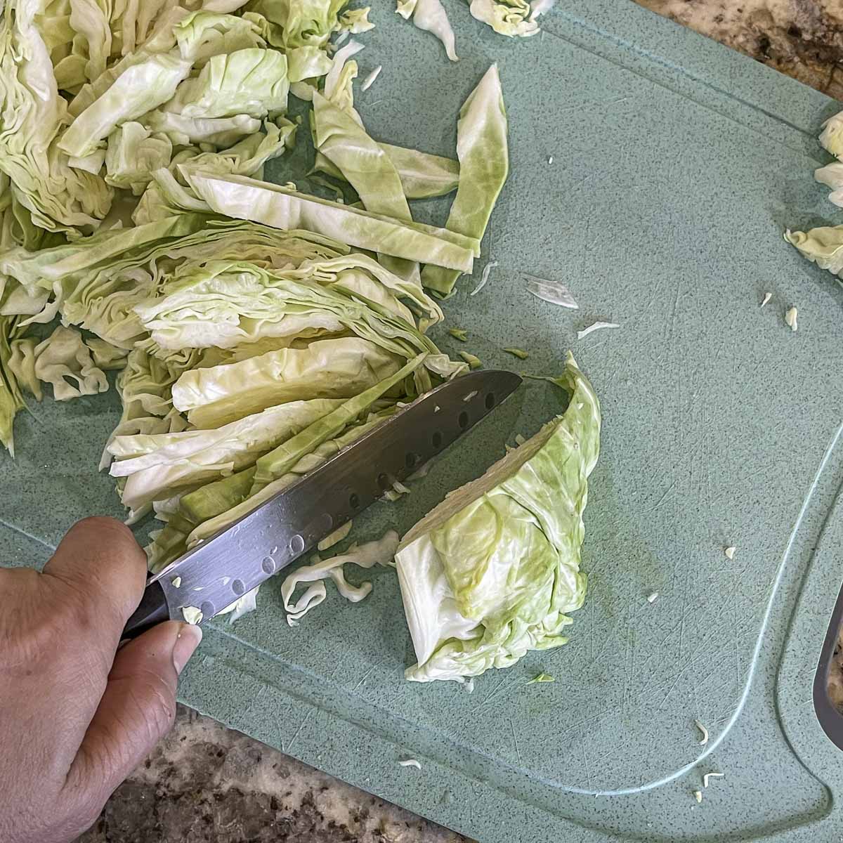 chopping cabbage on a blue cutting board