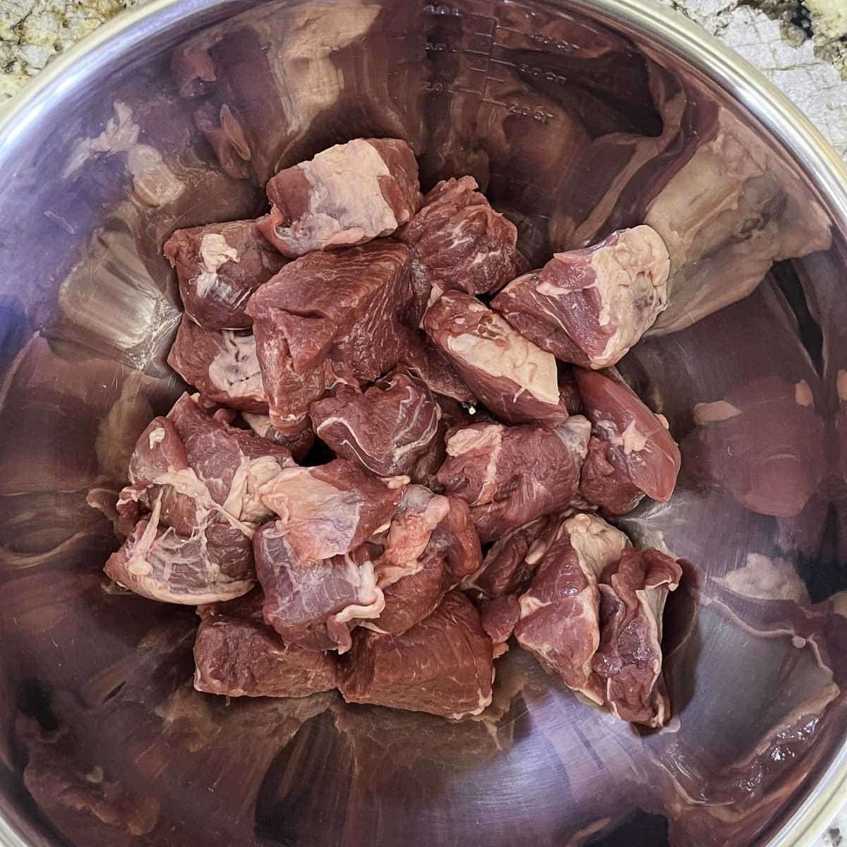cubed raw lamb in a silver bowl