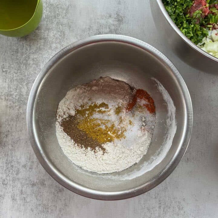 a silver bowl with flour and spices.