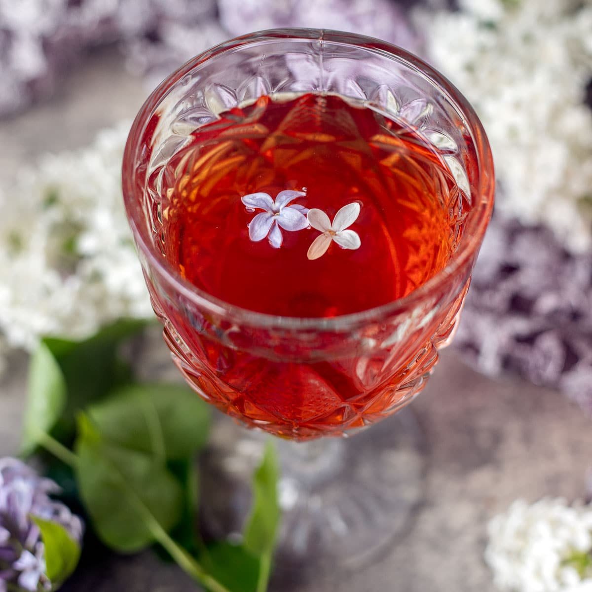 lilac wine with lilacs around it