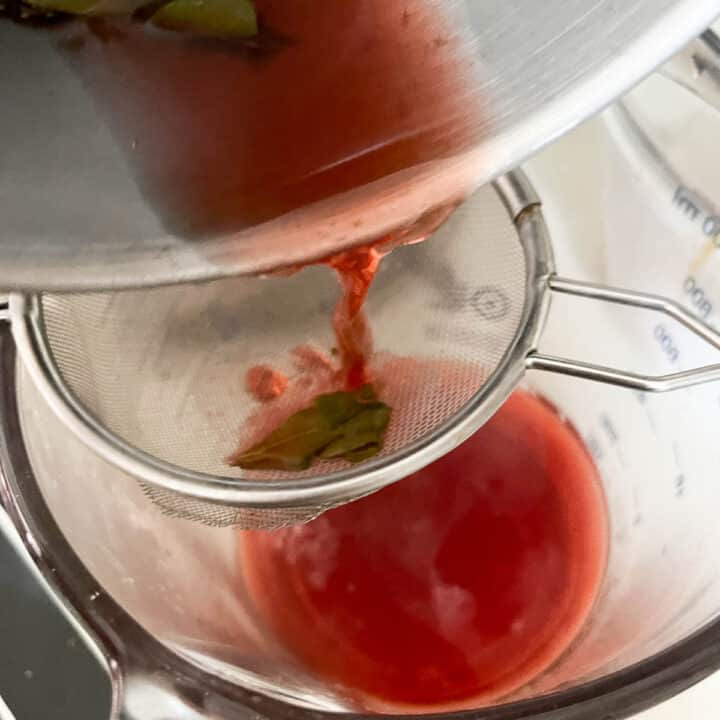 pouring loquat leaf tea through a strainer