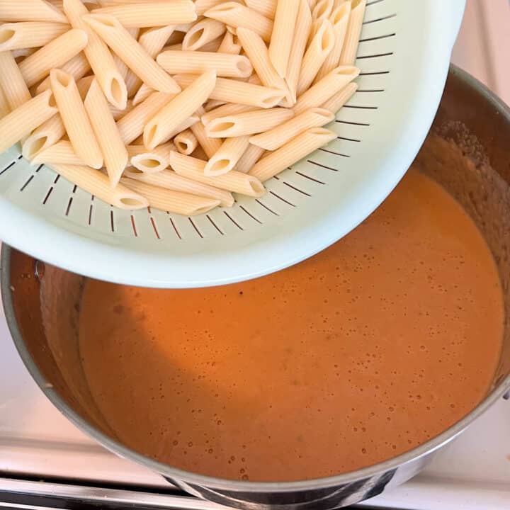 penne pasta being added  to rosa sauce