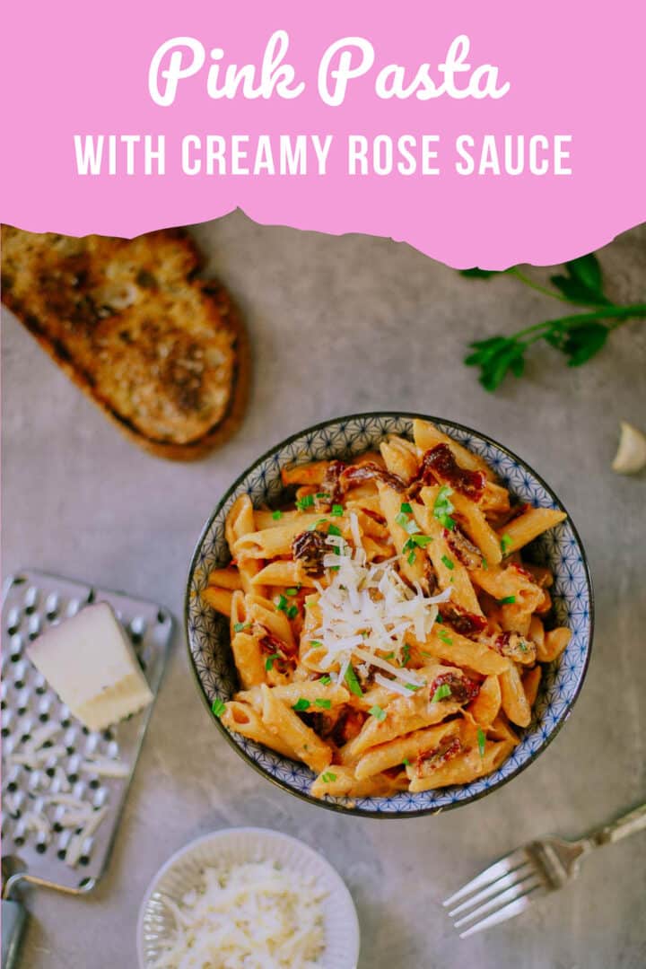 pink pasta with cheese and bread around it