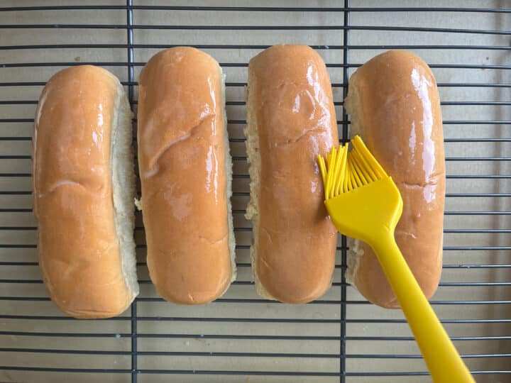 hot dog buns being brushed with egg wash