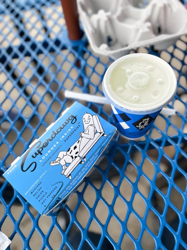 superdawg in a blue box with a drink next to it