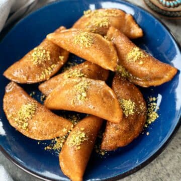 a blue plate with Atayef, middle eastern pastries