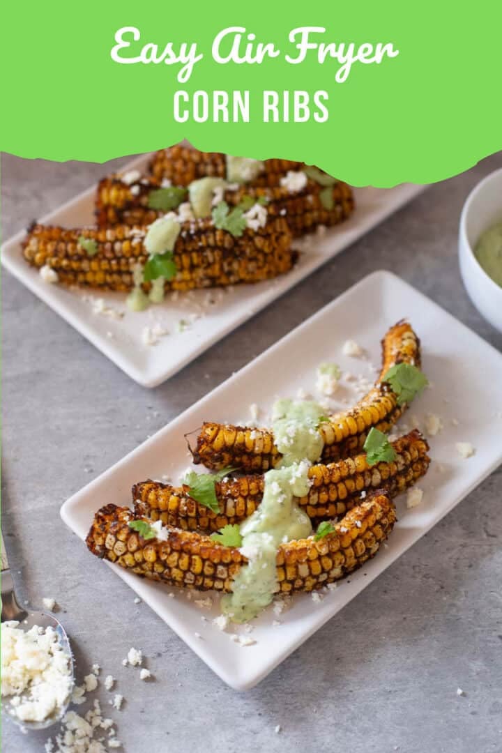 corn ribs with cotija cheese in a spoon and cilantro lime sauce in bowl