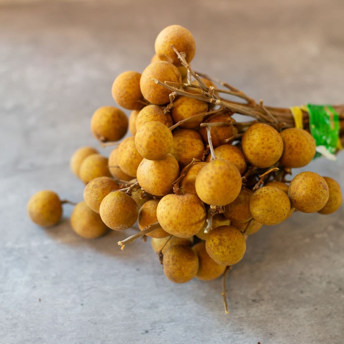 a bunch of whole longan fruits tied with rubber band