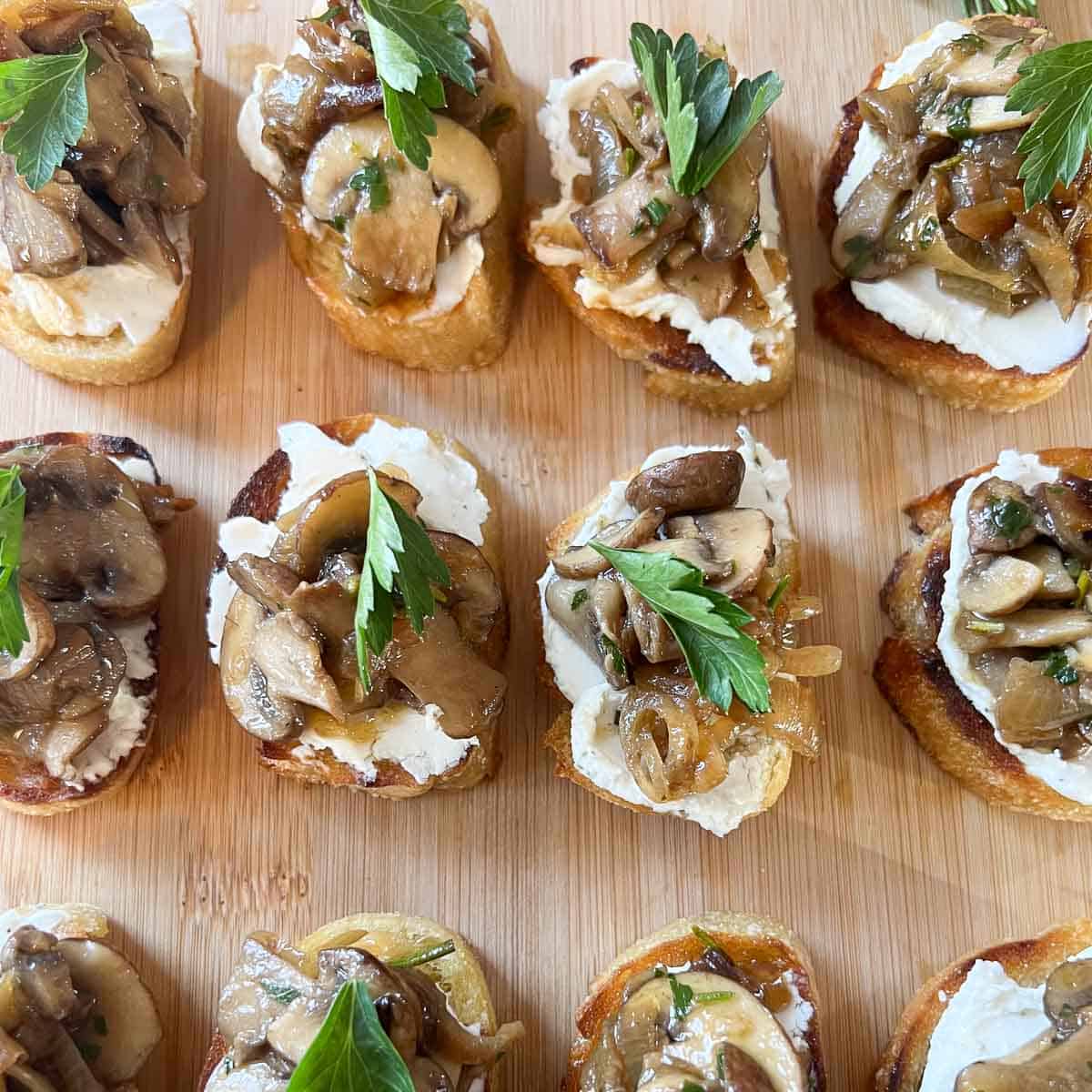 mushroom goat cheese bruschetta on cutting board garnished with parsley