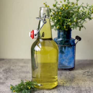 pineapple weed tea in a bottle with pineapple flowers in a vase