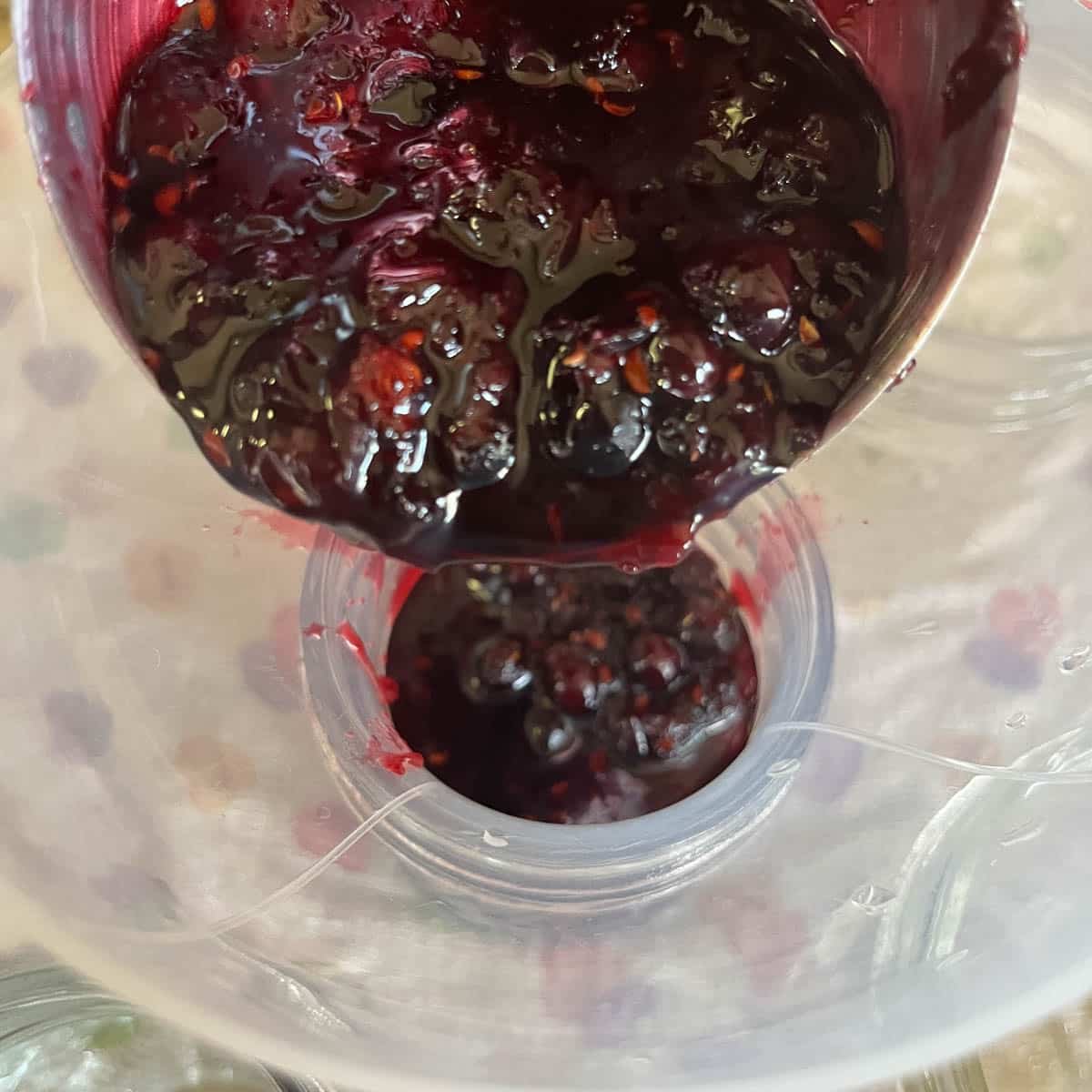 pouring jam through funnel into jar