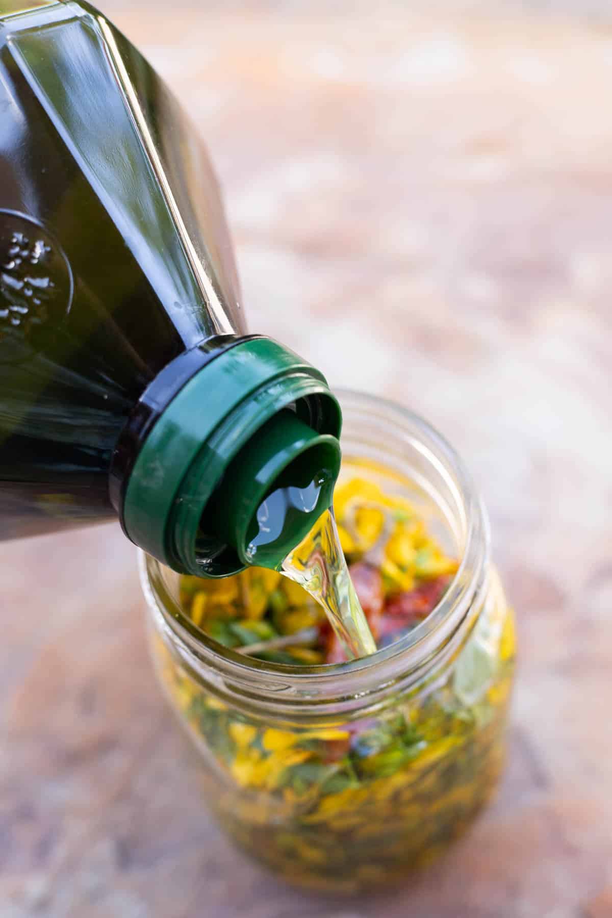 adding oil to a jar of flowers