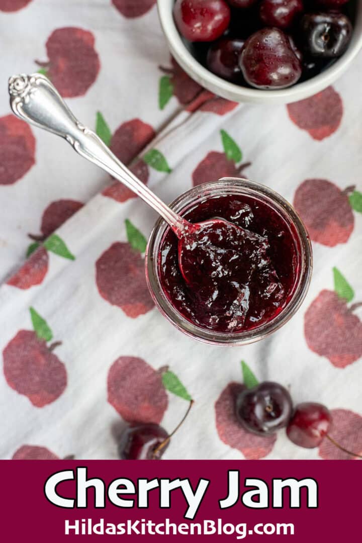 cherry jam in a jar with cherries around it