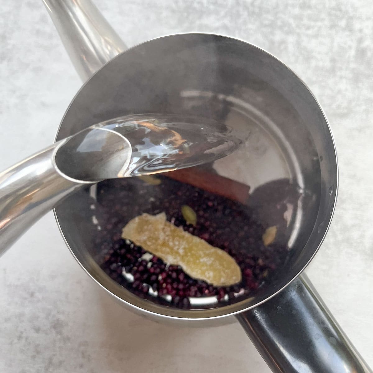 pouring water over spices in pot