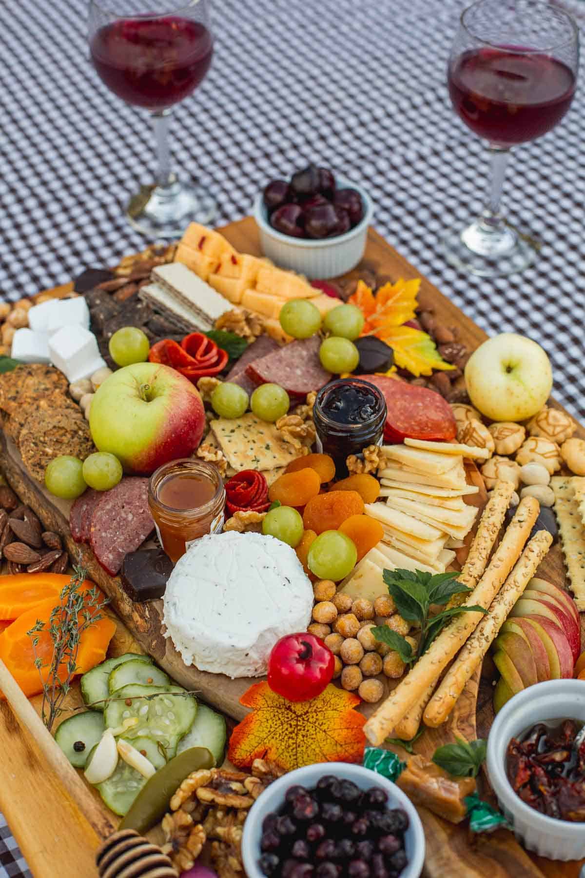 fall charcuterie board with two wine glasses