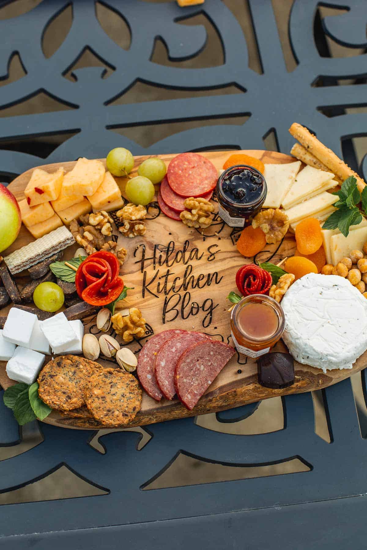 charcuterie surrounding the words "hilda's kitchen blog" engraved on cutting board