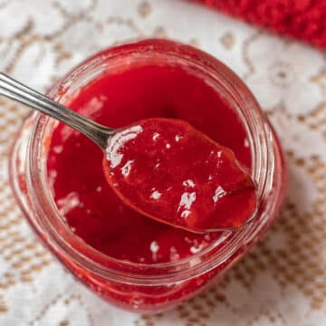 plum jam in a jar with a spoon