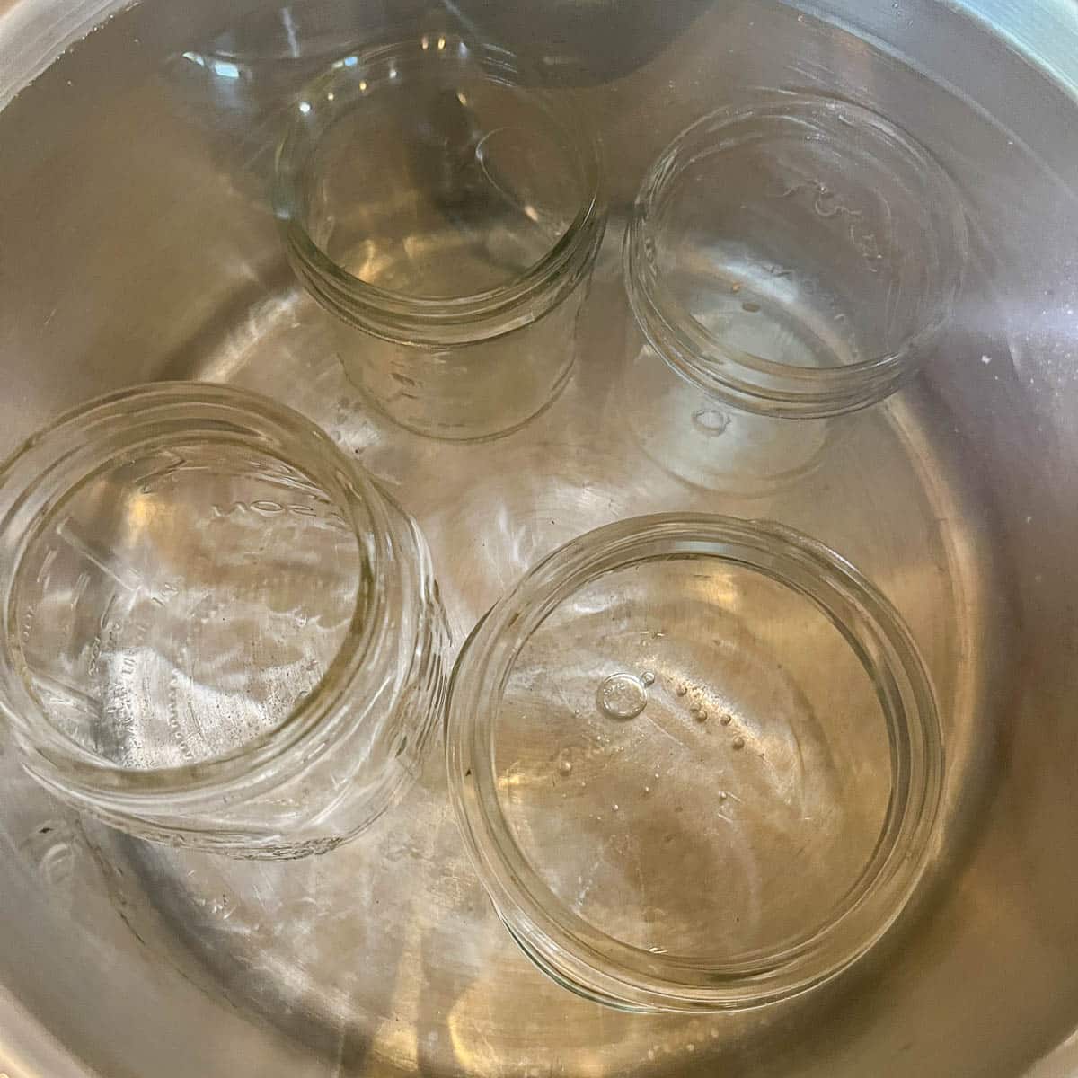 jars being sterilized in a pot of water 