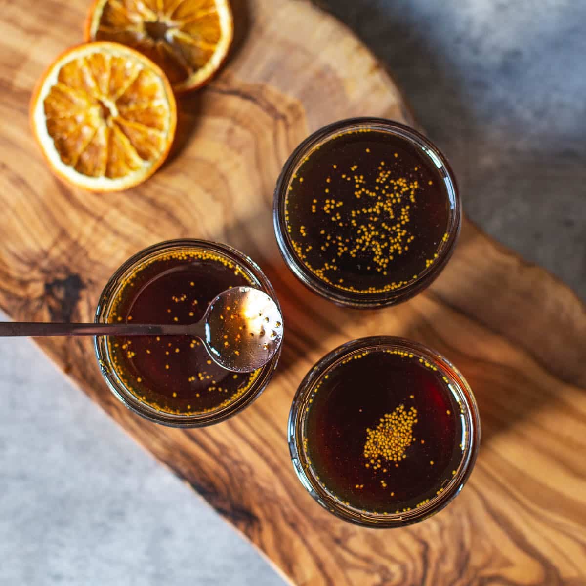three jars of fig syrup on cutting board