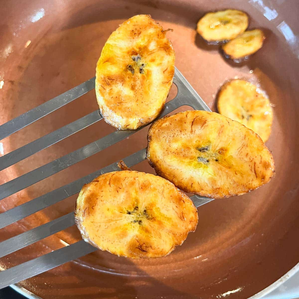 golden brown plantains on spatula