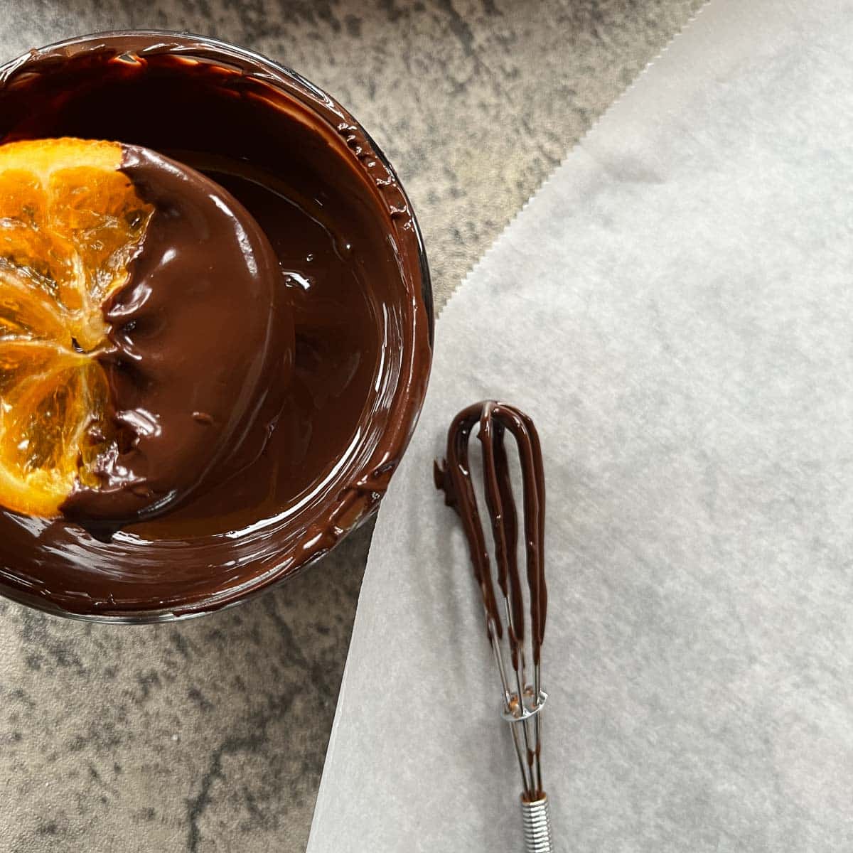 dipping orange slices into melted dark chocolate