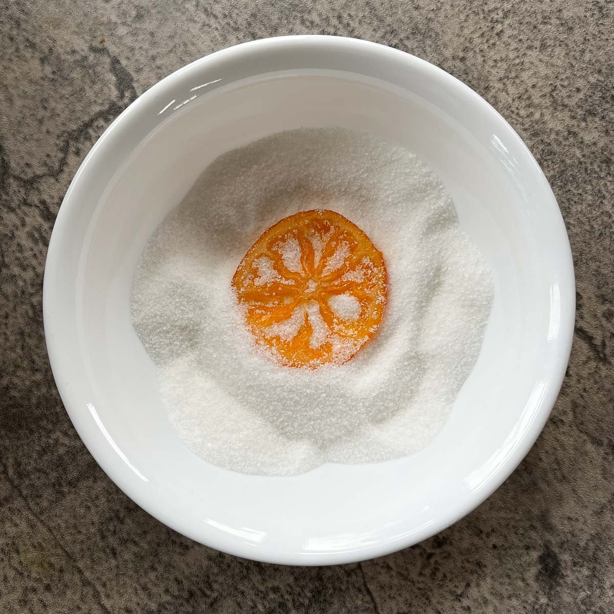 orange slices in a small bowl of sugar