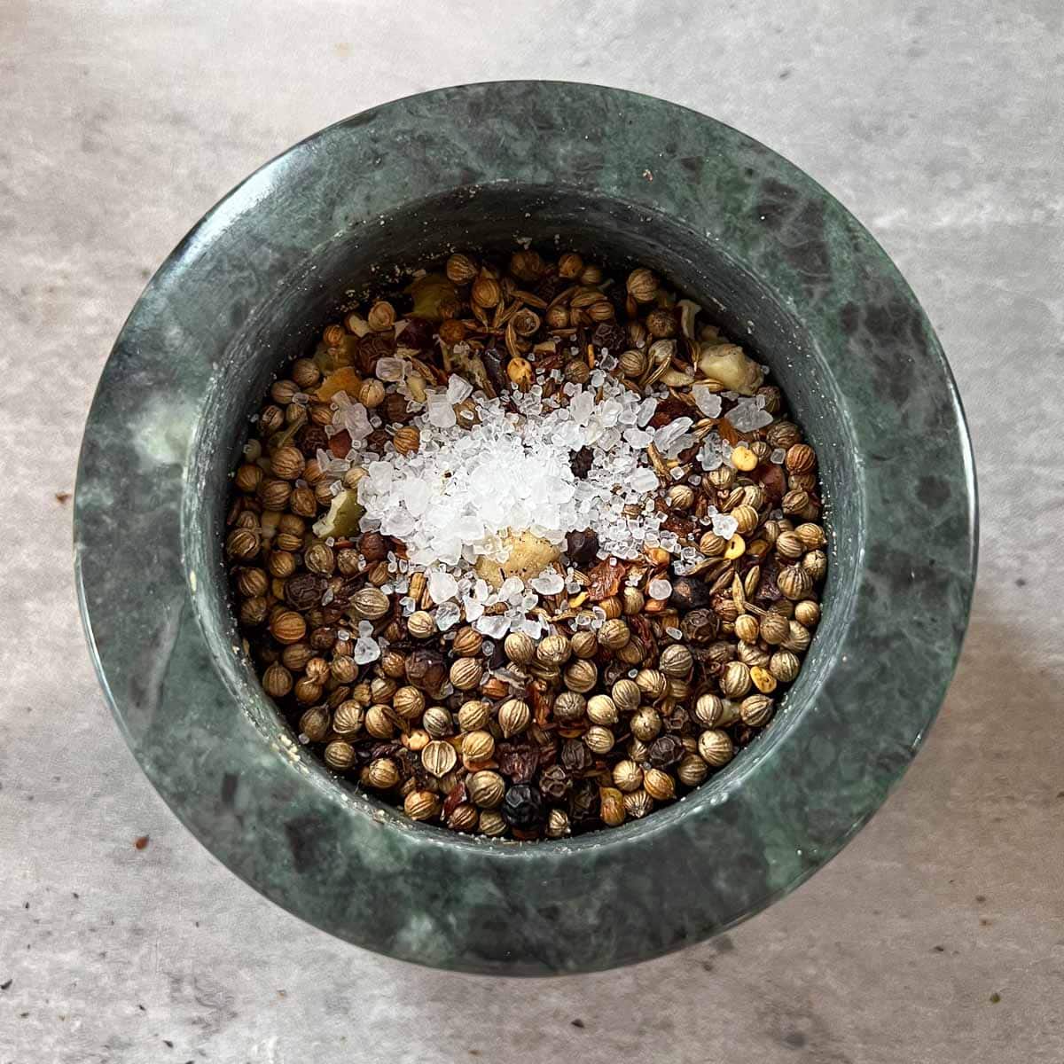 seasonings added to hazelnuts and pepitas in mortar