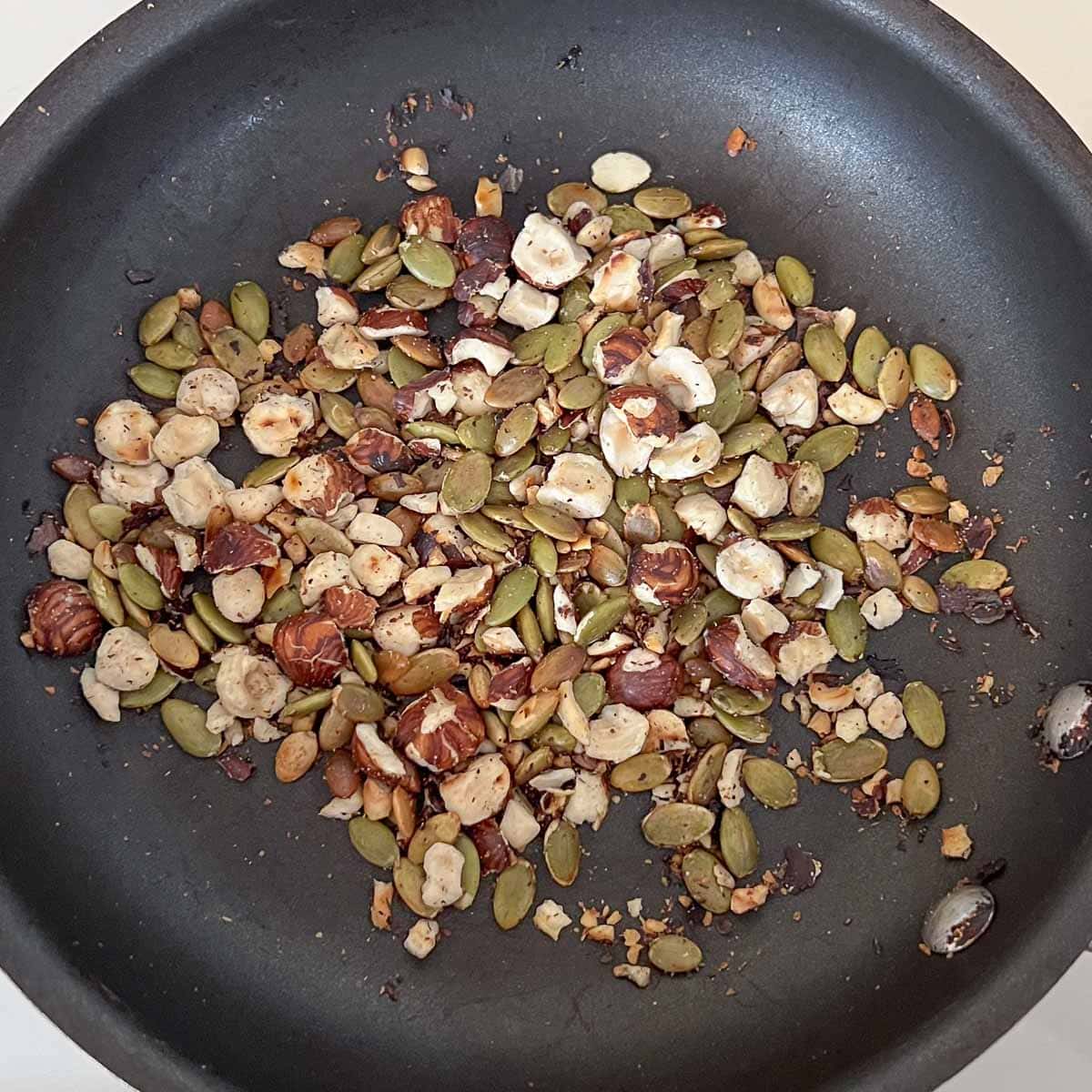 toasted hazelnuts and pumpkin seeds in pan