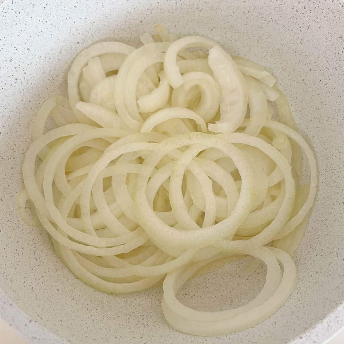 raw onions in pot before cooking