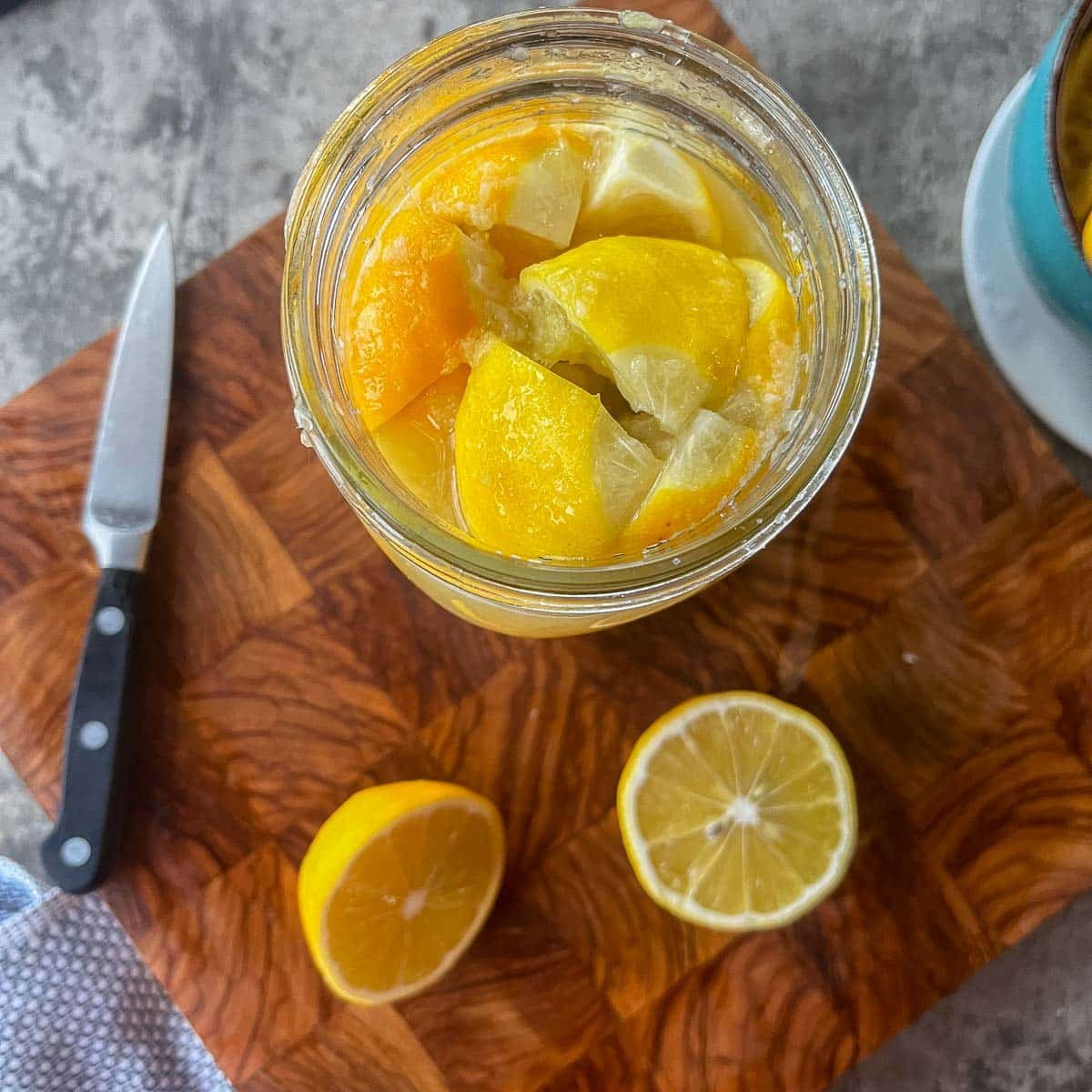 sliced lemons in a jar with a sliced lemon next to it